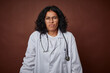 © Asier - Young colombian doctor woman with stethoscope shrugs shoulders and open eyes confused.