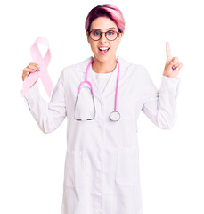 Poster - Young beautiful woman with pink hair wearing doctor stethoscope holding cancer ribbon surprised with an idea or question pointing finger with happy face, number one