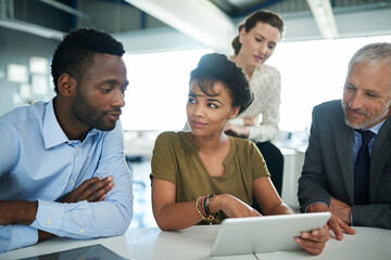 Aufkleber - Everyones in on this project. Shot of a group of businesspeople talking together over a digital tablet in an office.