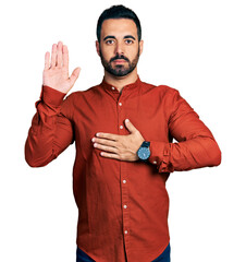 Sticker - Young hispanic man with beard wearing casual shirt swearing with hand on chest and open palm, making a loyalty promise oath