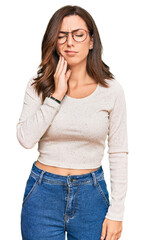 Canvas Print - Young brunette woman wearing casual clothes and glasses touching mouth with hand with painful expression because of toothache or dental illness on teeth. dentist