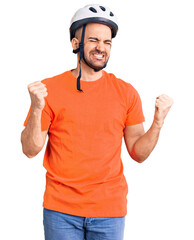 Canvas Print - Young handsome man wearing bike helmet very happy and excited doing winner gesture with arms raised, smiling and screaming for success. celebration concept.