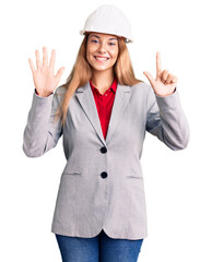 Canvas Print - Beautiful young woman wearing architect hardhat showing and pointing up with fingers number seven while smiling confident and happy.