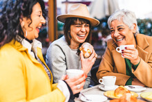 Group Of Senior Women At Bar Cafeteria Enjoying Breakfast Drinking Coffee And Eating Croissant - Life Style Concept - Mature Female Having Fun At Bistrò Cafe And Sharing Time Together 