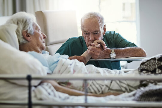 love is always being there for each other. shot of a senior man visiting his wife in hospital.