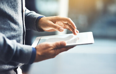 Poster - Its the handiest device you could use. Closeup shot of an unrecognisable businessman using a digital tablet in an office.