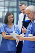 © Adene S/peopleimages.com - These are some promising results. Shot of a group of doctors talking together over a digital tablet while standing in a hospital.