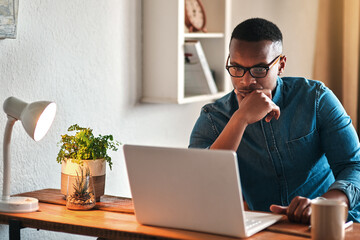 Aufkleber - I wonder what I should do here. Cropped shot of a handsome young businessman sitting in his home office and looking contemplative while working on his laptop.