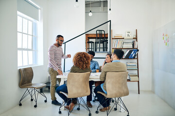 Success, youve gotta plan for it. Shot of a group of colleagues having a meeting in a modern office.