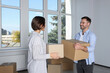 © New Africa - Happy couple with moving boxes near big window in new apartment