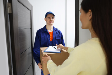 Canvas Print - Woman receiving parcel from courier at home