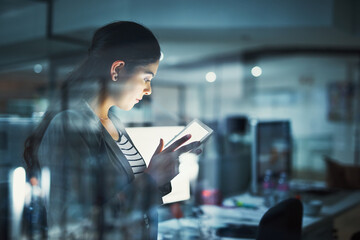 Poster - alone in the office getting work done. shot of a young businesswoman working late in the office.