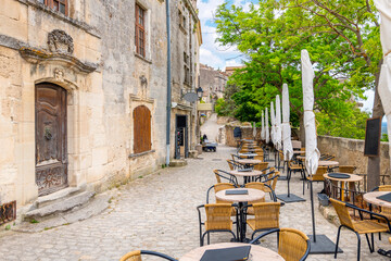 Wall Mural - An outdoor cafe overlooking the Alpilles mountains and the valley of Les Baux in the medieval old town of Les Baux-de-Provence, in the Provence region of Southern France.	