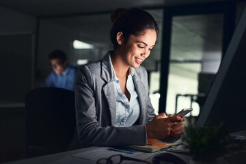 Leinwandbilder - My productivity wont stop because of the time. Shot of a young attractive businesswoman working late at night in a modern office.