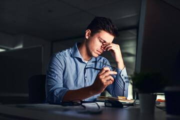 Leinwandbilder - Putting in those overtime hours. Shot of a young businessman working late at night in a modern office.
