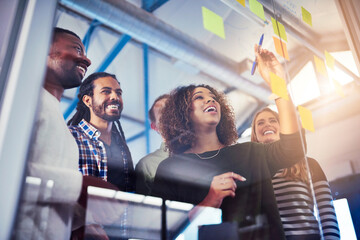 Fototapete - Working their way through different solutions. Shot of colleagues having a brainstorming session with sticky notes at work.