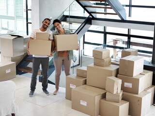 Poster - Starting a new life together in a new home. Portrait of a happy young couple carrying boxes while moving into their new home.