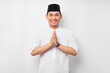 © Bangun Stock Photo - Happy smiling young Asian Muslim man in Arabic costume standing with gesturing Eid Mubarak greeting and welcoming Ramadan isolated on white background. People religious Islamic lifestyle concept