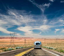 COLORADO RIVER, ARIZONA, USA. An Airstream Trailer Rolls Down A Wide-open Road In A Desert Landscape.