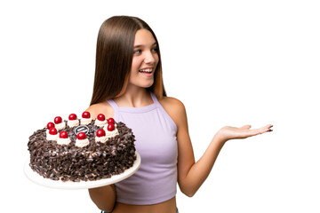 Canvas Print - Teenager caucasian girl holding birthday cake over isolated background with surprise facial expression