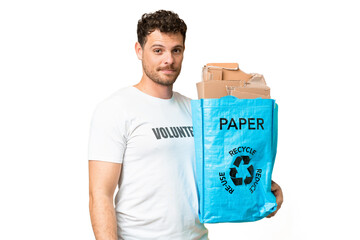 Wall Mural - Brazilian man holding a recycling bag full of paper to recycle over isolated chroma key background smiling a lot