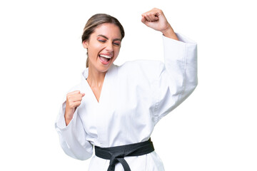 Wall Mural - Young Uruguayan woman doing karate over isolated background celebrating a victory