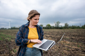 Aufkleber - Farmer with laptop on the field. Wind turbines on a horizon. Smart sustainable farming and agriculture digitalization	
