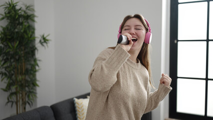 Sticker - Young blonde woman listening to music singing song at home