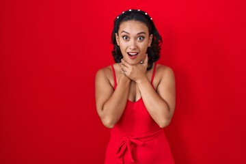 Wall Mural - Young hispanic woman standing over red background shouting and suffocate because painful strangle. health problem. asphyxiate and suicide concept.