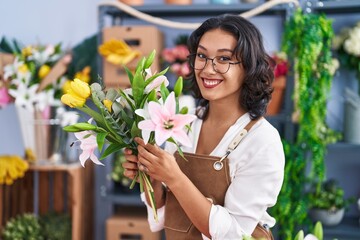 Canvas Print - Young beautiful hispanic woman florist holding bouquet of flowers at flower shop