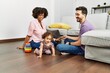 © Krakenimages.com - Couple and daughter smiling confident playing with toys sitting on the floor at home