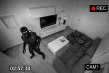 ROBBER STEALING IN A HOUSE CAPTURED ON SURVEILLANCE CAMERA. BURGLAR ALARM SYSTEM FOR SECURITY AT HOME.