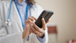 © Krakenimages.com - Young beautiful hispanic woman doctor using smartphone at clinic