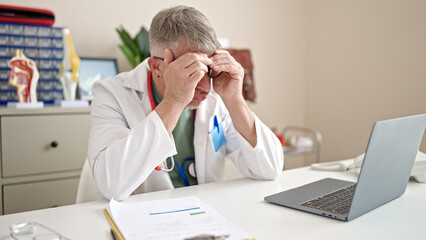 Poster - Middle age grey-haired man doctor stressed working at clinic