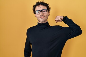 Sticker - Hispanic man standing over yellow background stretching back, tired and relaxed, sleepy and yawning for early morning