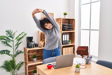 Poster - Young middle east woman business worker stretching arms at office