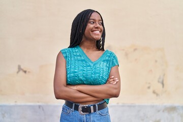 Wall Mural - African american woman smiling confident standing with arms crossed gesture at street