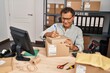 © Krakenimages.com - Middle age man ecommerce business worker writing on package at office