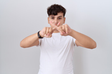 Poster - Young non binary man wearing casual white t shirt rejection expression crossing fingers doing negative sign