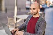 © Krakenimages.com - Young man using laptop sitting on table at coffee shop terrace