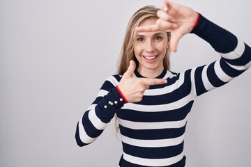 Canvas Print - Young caucasian woman wearing casual navy sweater smiling making frame with hands and fingers with happy face. creativity and photography concept.