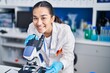 © Krakenimages.com - Young hispanic woman scientist using microscope at laboratory