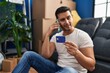 © Krakenimages.com - Young hispanic man talking on smartphone using credit card at new home