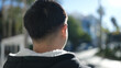 © Krakenimages.com - Young chinese man standing on back view at street
