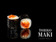 Side view of Maki sushi roll pieces with mirror reflection on black background. Sushi roll with flying fish roe Tobiko, cream cheese. Ready menu advertising banner with text and copy space.