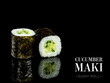 Side view of Maki sushi roll pieces with mirror reflection on black background. Sushi roll with cucumber and nori seaweed on top. Ready menu advertising banner with text and copy space.