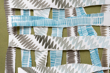 Poster - torn paper stripes with somewhat wavy edges decorated with stained patterns arranged in a loose grid form on rough green paper