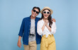 Excited Asian couple tourist dressed in summer clothes to travel on holidays isolated on blue background.