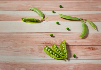 Fresh organic pea pods on a woody background.