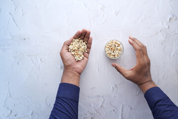Wall Mural - top view of hand pick peanuts from a jar 
